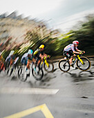 Paris, France - 27 July 2025: View of cyclists of the Tour de France 2025 speeding through the city streets, a blur of vibrant colors against the grey backdrop of a rainy day.