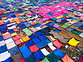 Luftaufnahme eines farbenfrohen Meeres von Zelten, die sich auf einem Feld in Dhaka ausbreiten und einen Flickenteppich aus Texturen und Farbtönen bilden, die unter freiem Himmel tanzen, Dhaka, Dhaka Division, Bangladesch.