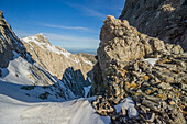 Blick auf zerklüftete, schneebedeckte Berggipfel unter einem strahlend blauen Himmel, der raue Texturen und ruhige Höhen gegenüberstellt, Litochoro, Larisa, Griechenland.