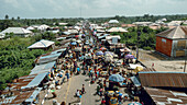 Ipare, Nigeria - 22 November 2024: Aerial view of a bustling market street teeming with vibrant colors, a symphony of human activity under the vast Nigerian sky.