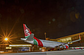 Nairobi, Kenya - 26 August 2014: View of a Kenya Airways plane at Embakasi, gleaming under the bright lights against the inky night sky, its red, green, and white livery sharply contrasting.