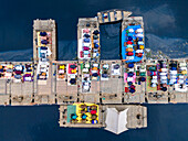 Luftaufnahme von Gläubigen, die zum Gebet auf einer schwimmenden Struktur knien. Ihre farbenfrohe Kleidung bildet einen lebhaften Kontrast zum dunklen Wasser, Tongi, Dhaka Division, Bangladesch.
