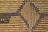 Luftaufnahme von goldenen Reishalmen, die unter der Sonne in geometrischen Mustern angeordnet sind und eine strukturierte Landschaft der ländlichen Industrie bilden, Thakurgaon, Bezirk Thakurgaon, Bangladesch.