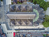 Luftaufnahme der geometrischen Dachziegel der Kirche Saint-Éloi und der umgebenden städtischen Struktur, die einen fesselnden Kontrast von Texturen und Farbtönen darstellt, Dünkirchen, Frankreich.