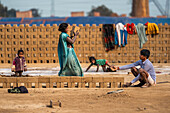 Kolkata, India - 28 January 2023: View of a family working together, their colorful clothes a stark contrast against the muted tones of the brickyard.