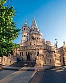 View of the Fisherman's Bastion with its ornate towers and stone facade basking in the warm glow of the morning sun, Budapest, Hungary.