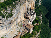 Aerial view of the Sanctuary of Madonna della Corona clinging dramatically to the sheer rock face, a testament to faith and architecture, Madonna della Corona, Veneto, Italy.