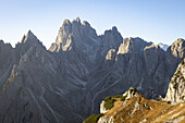Blick auf zerklüftete Berggipfel, die sich dramatisch erheben und lange Schatten auf die zerklüftete, felsige Landschaft in Misurina, Belluno, Italien, werfen.