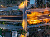 Aerial view of illuminated roads and a bridge cutting through the night, its lights painting streaks of gold against the dark canvas of the city, Chania, Chania, Greece.