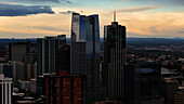 Aerial view of skyscrapers piercing the twilight sky, their glass facades reflecting the fading light above Denver's bustling cityscape, Denver, Colorado, United States.