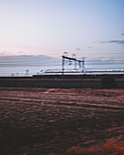 Shinakafuchigawa Bridge, Japan - 02 March 2025: View of a high-speed train blurring past a field under a pastel sky, a streak of modern motion against a backdrop of serene twilight.