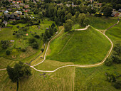 Luftaufnahme des üppig grünen Merkine-Hügels, ein lebhafter Kontrast zu den umliegenden Feldern und Wäldern, eine ruhige Landschaft, Merkine, Litauen.