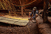 Dhaka, Bangladesh - 25 October 2019: View of a worker amidst a shower of sparks as he grinds metal at a shipyard, the raw steel contrasting with the dark, gritty surroundings.