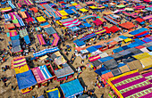 Bogura, Bangladesh - 09 February 2022: Aerial view of a vibrant tapestry of market stalls, each adorned with colorful canopies, bustling with activity and commerce.
