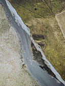 Aerial view of a river carving through a landscape of contrasting textures and tones, defining the earth's raw beauty, Mers-les-Bains, Hauts-de-France, France.