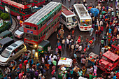 Dhaka, Bangladesh - 13 September 2015: Aerial view of a bustling intersection where vibrant buses, rickshaws, and crowds converge in a symphony of motion, color, and urban energy.