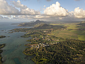 Aerial view of beautiful coastline with tranquil ocean, lush mountain, and picturesque village, Flacq, Mauritius.