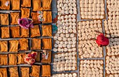 Bogura, Bangladesh - 23 March 2023: Aerial view of the golden and white hues of food drying in the sun, women in vibrant saris adding splashes of color.