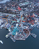 Luftaufnahme der Fahrgeschäfte und Attraktionen des Vergnügungsparks Gröna Lund vor der Kulisse der Stockholmer Gebäude und Wasserstraßen, Schweden, Stockholm, Region Stockholm, Schweden.