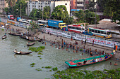 Dhaka, Bangladesh - 09 September 2015: Aerial view of the vibrant riverbank where life unfolds in a tapestry of activity, boats gently glide on the shimmering water.