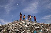 Chittagong, Bangladesch - 09. September 2022: Blick auf Kinder auf einem Müllberg, ihre kleinen Gestalten heben sich vom weiten, hellen Himmel ab - ein ergreifender Kontrast der Hoffnung inmitten der Trostlosigkeit.