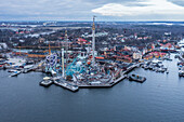 Luftaufnahme des Vergnügungsparks Gröna Lund mit seinen hoch aufragenden Fahrgeschäften und Achterbahnen vor dem Hintergrund des ruhigen Wassers, Stockholm, Provinz Stockholm, Schweden.