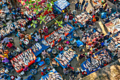 Bogura, Bangladesch - 18. November 2021: Luftaufnahme eines belebten Fischmarktes mit Verkäufern, die ihren frischen Fang unter bunten Planen ausstellen und so ein lebendiges Mosaik aus Handel und Gemeinschaft schaffen.