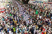 Chattogram, Bangladesh - 08 October 2022: View of a dense crowd gathered under the flyover, their flags creating a sea of green against the urban backdrop.