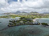 Aerial view of ilot lievres with beautiful white sand beach and turquoise lagoon surrounded by palm trees and scenic mountains, Flacq District, Mauritius.