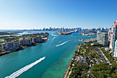 Luftaufnahme von türkisfarbenen Wasserstraßen, die sich durch üppig grüne Inseln in Richtung der entfernten Skyline ziehen, wo städtische Strukturen auf den weiten Ozean treffen, Miami Beach, Florida, Vereinigte Staaten.