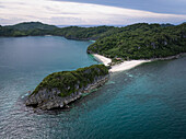 Luftaufnahme einer atemberaubenden tropischen Insel mit üppiger grüner Vegetation, die auf unberührten weißen Sand trifft, umgeben von den tiefen Blautönen des Ozeans, Caramoan, Camarines Sur, Philippinen.