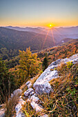 View of golden sunlight bathes the Velka Fatra mountains, illuminating autumn foliage and rocky outcrops in a vibrant display of nature's beauty, Blatnica, Žilina Region, Slovakia.