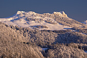 View of a pristine, snow-laden mountain range glistens under the golden touch of sunlight, Cierny Kamen peak, contrasting with the cool, deep blue sky above, Staré Hory, Banskobystrický kraj, Slovakia.