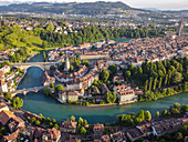 Luftaufnahme der Aare, die sich um die Altstadt mit ihren charakteristischen roten Ziegeldächern und dem hoch aufragenden Berner Münster windet, Bern, Kanton Bern, Schweiz.