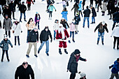 New York, Vereinigte Staaten - 07. Dezember 2018: Blick auf festliche Schlittschuhläufer, die auf einer Freiluft-Eisbahn über das Eis gleiten, wobei der Weihnachtsmann inmitten der geschäftigen Menschenmenge einen Hauch von Weihnachtszauber verbreitet.