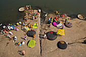 Hampi, India - 30 December 2010: Aerial view of women in vibrant saris washing clothes on the Tungabhadra River's rocky banks, colors pop against the earth tones.