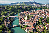 Luftaufnahme der Aare, die sich durch die Altstadt schlängelt, mit Bogenbrücken, die die historischen Gebäude unter einem hellen Himmel verbinden, Bern, Kanton Bern, Schweiz.