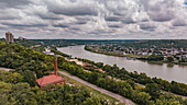 Aerial view of the Ohio River flowing serenely, flanked by lush greenery and the historic brick smokestack structure, Cincinnati, Ohio, United States.