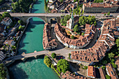 Luftaufnahme der türkisfarbenen Aare, die sich um die Altstadt mit ihren charakteristischen roten Ziegeldächern und der Nydeggkirche windet, Bern, Kanton Bern, Schweiz.