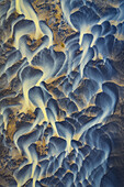 Aerial view of glacial river patterns form abstract art across the landscape, where icy blues meet earthy yellows in a stunning natural display, Iceland, Iceland.
