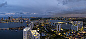 Aerial view of the city lights reflecting off the water, illuminating the coastline and buildings of Aventura, Florida, United States.
