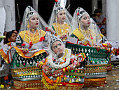 Sylhet, Bangladesh - 08 November 2022: View of radiant Manipuri girls adorned in vibrant green, gold, and white traditional attire, their serene expressions contrasting against the festive backdrop.