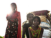 Chattogram, Bangladesch - 04. Oktober 2022: Blick auf Kinder, die vor einem Hintergrund von aufgestapelten Säcken stehen, ihre Gesichter spiegeln in der grellen Sonne Widerstandsfähigkeit wider.