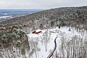 Luftaufnahme von schneebedeckten Bäumen und einer rustikalen Scheune in der Nähe des weißen Hauses, die eine ruhige Winterszene schaffen, Fawn Lake Forest, Pennsylvania, Vereinigte Staaten.