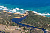 Luftaufnahme der Mündung des Gellibrand River in den türkisfarbenen Ozean, umrahmt von goldenem Sand und grünen Klippen, Princetown, Victoria, Australien.