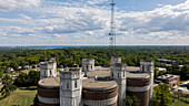 Aerial view of the bright, castle-like structure contrasts against the deep greens of the surrounding trees, with a tall tower reaching into the cloudy sky, St. Louis, Missouri, United States.