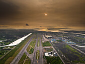 Aerial view of the ongoing construction work of Navi Mumbai International Airport(NMIA), runway, and the terminal building bathed in the warm glow of the sunset, Navi Mumbai, Maharashtra, India.