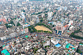 Dhaka, Bangladesh - 09 September 2025: Aerial view of the cityscape reveals a tapestry of dense buildings surrounding a vibrant green field, showcasing the bustling urban environment.