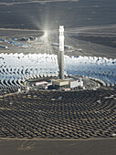 Aerial view of the solar power plant reflecting the sun's intense rays with a central tower piercing the sky, a beacon of sustainable energy, Turpan, Xinjiang, China.