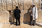 Jerusalem, Israel - 01. November 2019: Blick auf Gläubige beim Gebet vor der sonnenüberfluteten, alten Klagemauer, deren verwitterte Steine ein Zeugnis der Zeit sind und von geflüsterter Andacht widerhallen.